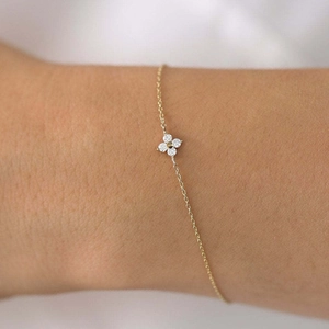 Detailaufnahme des goldenen Kleeblatt-Armbands mit Zirkonia-Steinen an einer feinen Kette