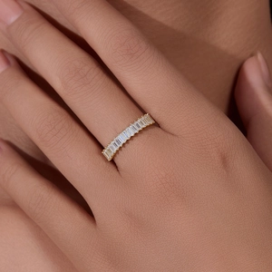 Macro shot of gold eternity ring with rectangular step-cut cubic zirconia gemstones