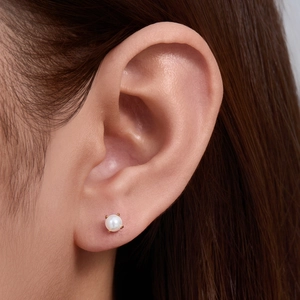 Detailed close-up of a high-quality 8mm white pearl stud earring on a female model