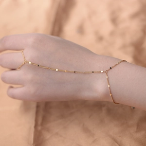 Minimalist gold s925 silver hand harness chain with sequins on a warm textured background