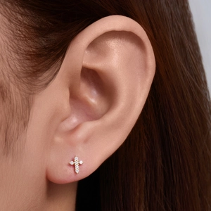 925 silver gold cross earring with cubic zirconia and opal on a model's ear
