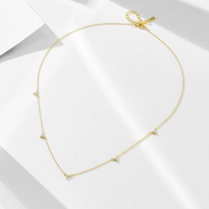 Minimalist gold S925 silver necklace with five clover zircon pendants on a white background