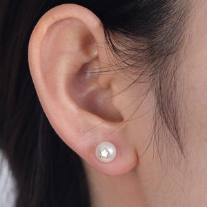 S925 silver pearl stud earring with gold star detail worn on ear for a retro French look