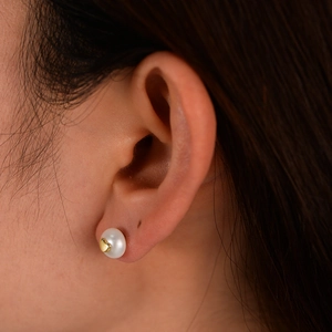 Close-up of a s925 silver heart pearl earring worn on the ear for a luxury style