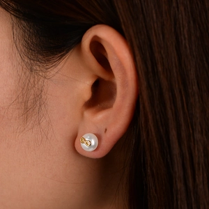 Close-up of S925 silver infinity pearl stud earrings worn on a female ear model
