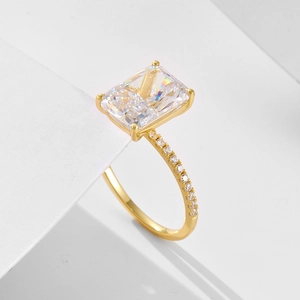 Golden S925 sterling silver ring with emerald cut zircon stone on geometric background