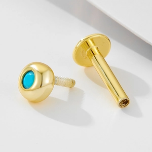 Detailed close-up of 925 silver gold earring with turquoise stone and screw thread design