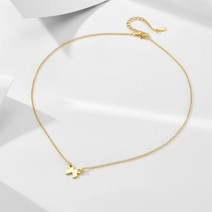 Detail of adjustable gold butterfly necklace with lobster clasp on white paper background
