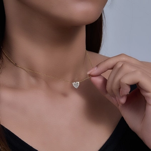Detail of s925 silver heart necklace with micro-paved sparkling cubic zirconia on a model