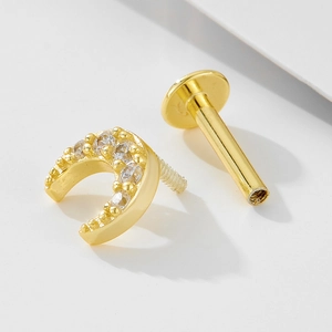 Detailed macro of golden crescent opal earring with sparkling zircons and flat back screw