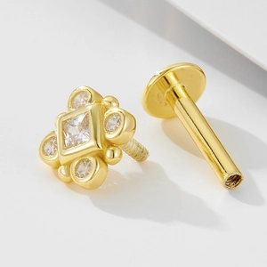 Macro view of gold 925 silver labret stud with cross design and sparkling cubic zirconia