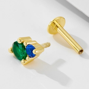 Macro shot of 925 silver labret with emerald and sapphire gems in prong setting