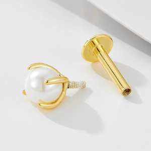 Macro detail of 925 sterling silver opal labret stud with gold-plated prong setting