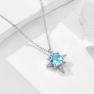 Pendente stella in argento S925 con topazio azzurro su uno sfondo di pietra bianca