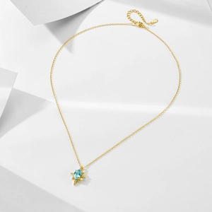 Dettaglio del ciondolo a stella in argento S925 con topazio azzurro e catena d'oro