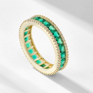 Golden emerald-cut green zircon eternity ring with shimmering pavé set accents