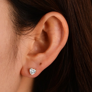 Elegant S925 sterling silver heart-shaped zircon stud earrings shown worn on ear