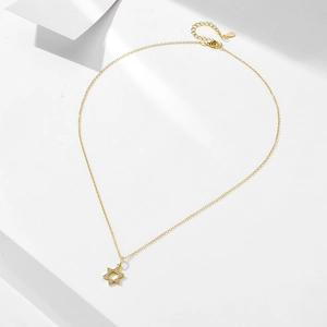 Detailed close-up of 14k gold plated 925 silver hexagram pendant with zircon accents