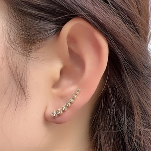 Détail d'un ear climber en argent S925 plaqué or 18 carats avec sept zircons dégradés