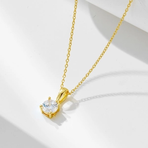 Close-up of a 925 silver necklace with a four-prong round zircon and gold finish