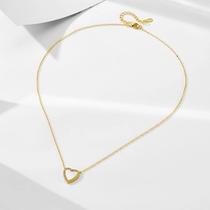 Dettaglio del ciondolo a cuore in madreperla con diamanti su una collana dorata