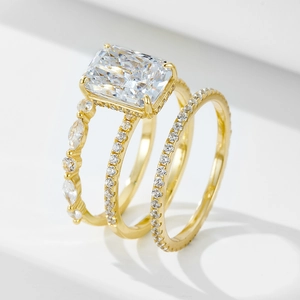 Detailed close-up of three-piece gold ring set featuring a large radiant cut center stone