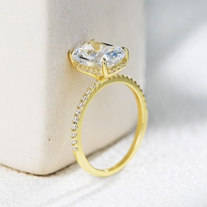 Macro side view of an 18K gold ring with a large radiant-cut stone and pavé diamond band