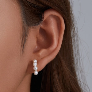 Elegant S925 silver earrings with four vertical white pearls shown on a female model