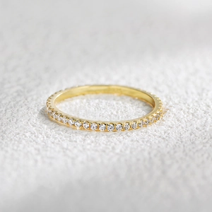 Macro shot of gold eternity ring band with pavé set white round cut cubic zirconia