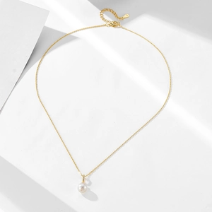 Close-up of S925 sterling silver stamp on a gold necklace with natural pearl pendant