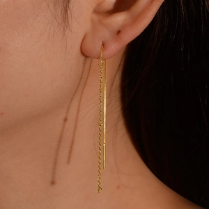 Elegant gold long tassel chain earrings with bead detail shown on a model