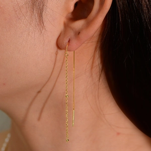 Close-up of minimalist S925 silver gold-plated long tassel ear thread with metal beads