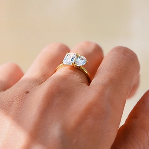 Macro shot of S925 silver ring featuring emerald and pear cut zircon stones on hand
