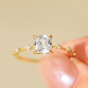 Close-up of square cut zircon ring with micro-pave diamonds in gold-toned finish