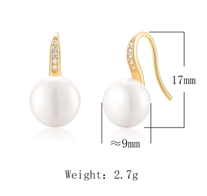 Detail view of gold pearl earrings with dimensions 17mm height and 9mm diameter