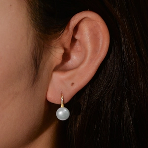 Close-up of s925 silver high heel earring with pearl and cubic zirconia on ear