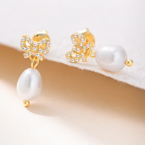 Vue détaillée de boucles d'oreilles nœud en argent 925 avec perles blanches tombantes