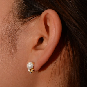Vue macro de boucles d'oreilles en argent S925 avec perle blanche et détails en zircon