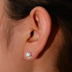 Detailed view of S925 silver V-shaped pearl stud earrings worn by a model in close-up