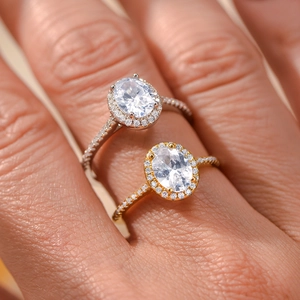 Macro shot of oval cut zircon halo ring with pave setting in silver and gold finish