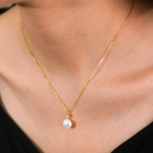 Close-up of elegant S925 silver gold-plated necklace featuring a natural pearl and diamond