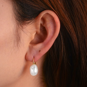 Close-up of S925 silver golden hook earring with irregular natural Baroque pearl