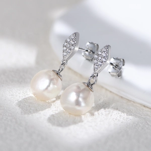 Macro shot of geometric S925 silver diamond earrings with lustrous natural pearls