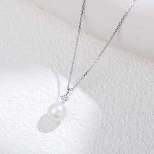 Close-up of a S925 sterling silver necklace featuring a round pearl with a small diamond