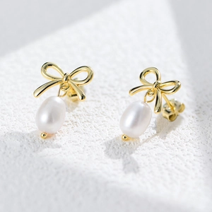 Elegant gold bow earrings with freshwater pearls shown in a close-up product shot