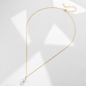 Detail of S925 silver necklace with golden chain, bread pearl pendant and small diamond