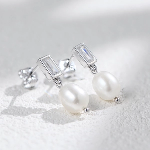 Vue macro des boucles d'oreilles en argent S925 avec zircon rectangulaire et perle d'eau douce