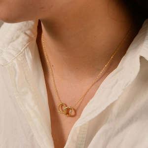 Close-up of twisted double ring pendant necklace on model with white shirt