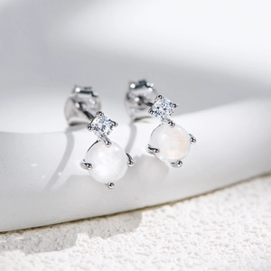 Macro detail of S925 silver stud earrings with moonstone and cubic zirconia inlay