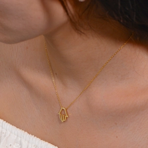 Nahaufnahme einer goldenen S925 Silber Hamsa-Hand-Halskette mit funkelnden Kristallen